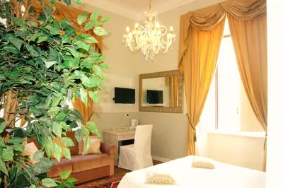 a living room with a chandelier and a plant at Charme Holidays Colosseum in Rome