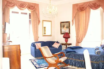 a living room with a blue couch and a chair at Charme Holidays Colosseum in Rome