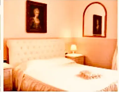 a bedroom with a white bed and a mirror at Charme Holidays Colosseum in Rome