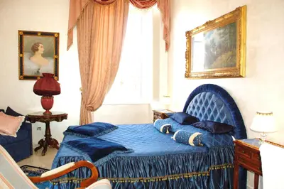 a bedroom with a blue bed with blue pillows at Charme Holidays Colosseum in Rome