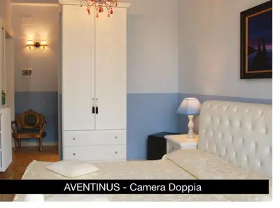 a bedroom with a white bed and a white cabinet at Charme Holidays Colosseum in Rome