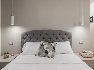 a bedroom with a large bed with a gray headboard at The Best Rent - Modern three-bedroom apartment a few steps from the Colosseum in Rome