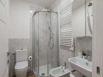 a bathroom with a shower and a toilet and a sink at The Best Rent - Modern three-bedroom apartment a few steps from the Colosseum in Rome