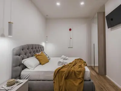 a bedroom with a large bed and a couch at The Best Rent - Modern three-bedroom apartment a few steps from the Colosseum in Rome