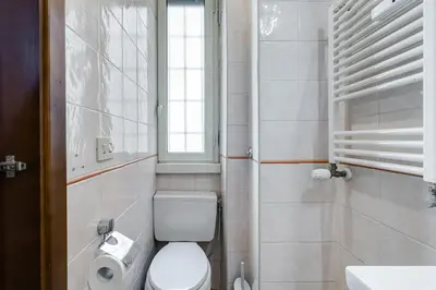 a bathroom with a toilet and a sink and a window at BDC - Egeria 3-Bdr huge apartment in Rome