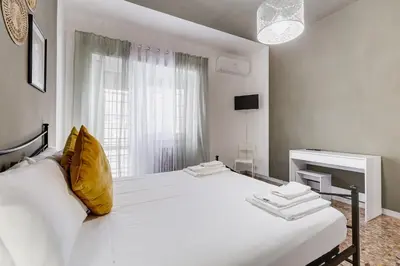 a white bedroom with a large white bed with yellow pillows at BDC - Egeria 3-Bdr huge apartment in Rome