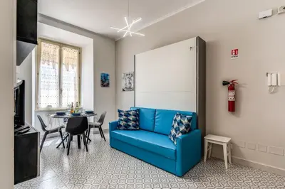 a living room with a blue couch and a table at Rhome Colosseum in Rome