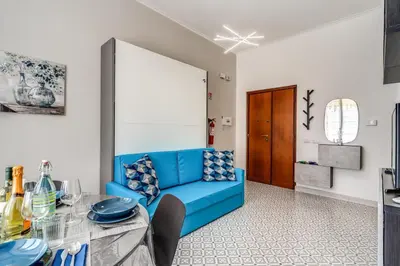 a living room with a blue couch and a table at Rhome Colosseum in Rome
