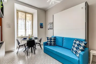 a living room with a blue couch and a table at Rhome Colosseum in Rome