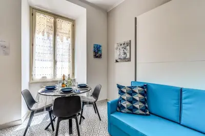 a dining room with a blue couch and a table at Rhome Colosseum in Rome