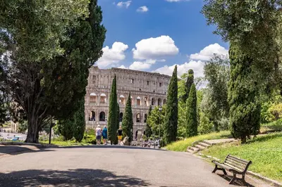 a park with a bench and a building in the background at Rhome Colosseum in Rome