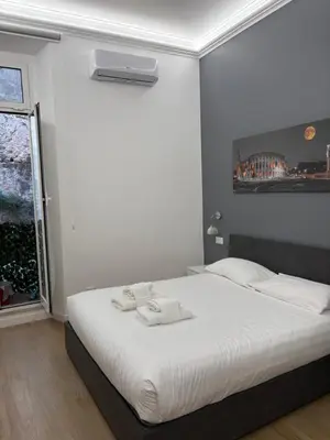 a bedroom with a white bed with towels on it at Colosseum romantic home in Rome