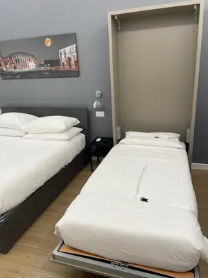 two beds in a room with white sheets at Colosseum romantic home in Rome