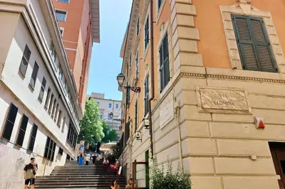 a group of people walking down a street next to a building at Colosseum romantic home in Rome