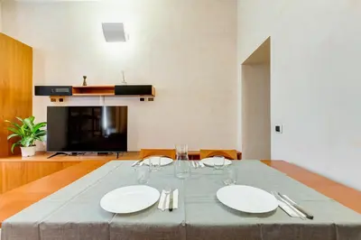 a dining room table with white plates and silverware at Vatican - Zen Style loft with Jacuzzi in Rome