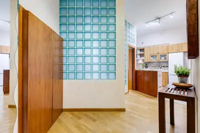 a kitchen with a wall with blue glass tiles at Vatican - Zen Style loft with Jacuzzi in Rome
