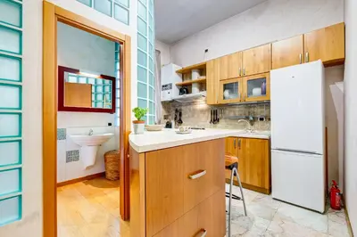 a kitchen with wooden cabinets and a white refrigerator at Vatican - Zen Style loft with Jacuzzi in Rome