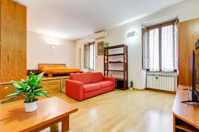 a living room with a red couch and a ladder at Vatican - Zen Style loft with Jacuzzi in Rome