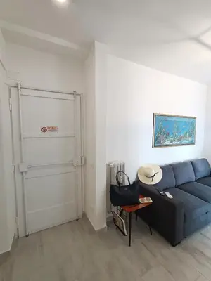 a living room with a blue couch and a door at La Terrazza sull'Appia by Hostand in Rome