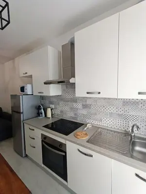 a kitchen with white cabinets and a stove top oven at La Terrazza sull'Appia by Hostand in Rome