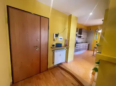 a large room with a wooden door and a kitchen at the sun in rome in Rome
