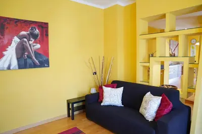 a living room with a blue couch and a painting at the sun in rome in Rome
