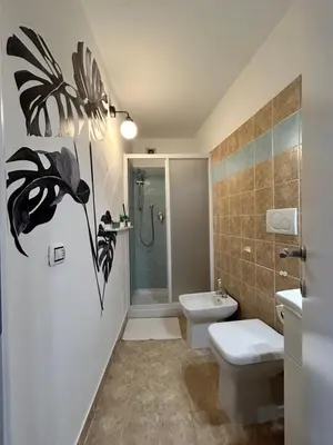 a bathroom with a shower and a toilet and a sink at Vita lenta terrazza Roma Garbatella in Rome