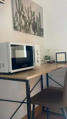 a microwave sitting on top of a wooden table at Vita lenta terrazza Roma Garbatella in Rome
