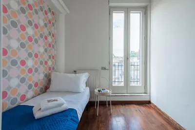 a bedroom with a bed and a large window at Colosseum Loft - ZENO 12 in Rome