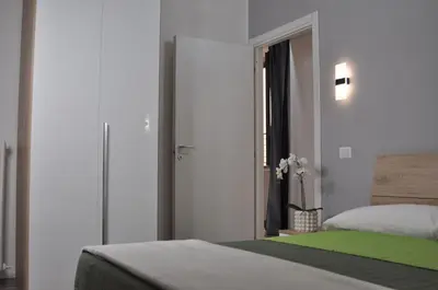 a bedroom with a bed with a green blanket at Big House Colosseo in Rome