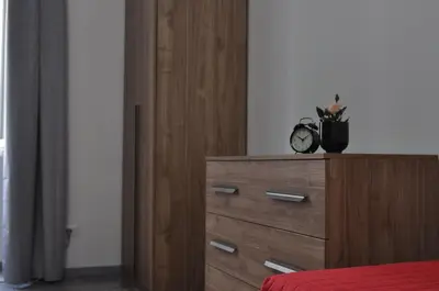 a bedroom with a dresser with a clock on it at Big House Colosseo in Rome