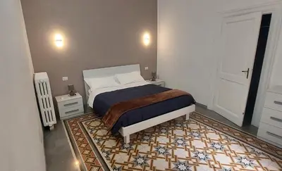 a bedroom with a bed and a rug at Big House Colosseo in Rome