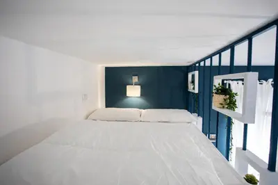 a white bed in a room with a blue wall at Belvedere pigneto in Rome