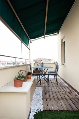 a patio with a table and chairs on a balcony at Belvedere pigneto in Rome