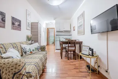 a living room with a couch and a television on a wall at Daniela, pied-à-terre al Vaticano in Rome