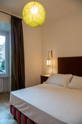 a bedroom with a large white bed and a window at Residenza Clodio Vatican in Rome