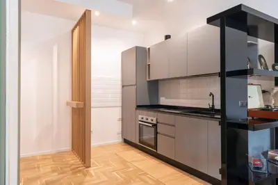 a kitchen with white cabinets and a wooden floor at Residenza Clodio Vatican in Rome