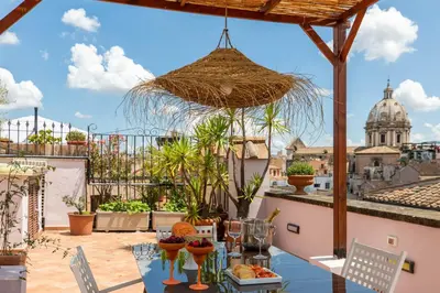 a patio with a table with a view of a city at iFlat Penthouse in Campo de' Fiori in Rome