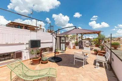 a patio with chairs and an umbrella on a building at iFlat Penthouse in Campo de' Fiori in Rome