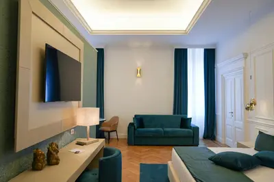 a room with a bed and a couch and a chair at Màs Boutique Hotel Rome in Rome