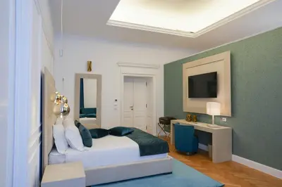 a bedroom with a bed and a desk and a television at Màs Boutique Hotel Rome in Rome