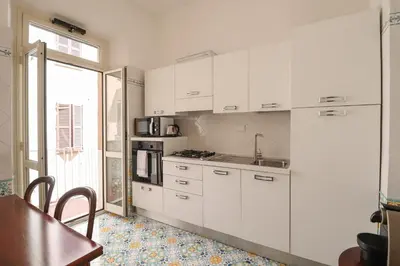 a kitchen with white cabinets and a table and a window at Casa Cecilia a Monti in Rome