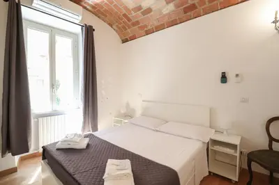 a bedroom with a bed and a large window at Casa Cecilia a Monti in Rome