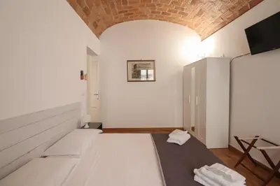 a room with a bed and a tv on the wall at Casa Cecilia a Monti in Rome