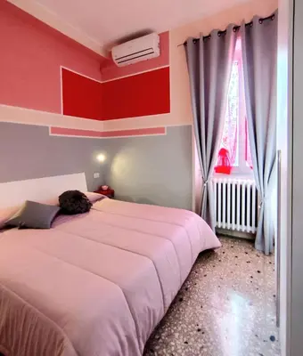 a bedroom with two beds and a red wall at Bed and Breakfast Mamma Giuliana in Rome