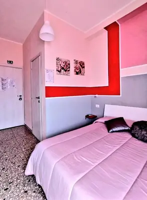 a bedroom with two beds and a red and white wall at Bed and Breakfast Mamma Giuliana in Rome