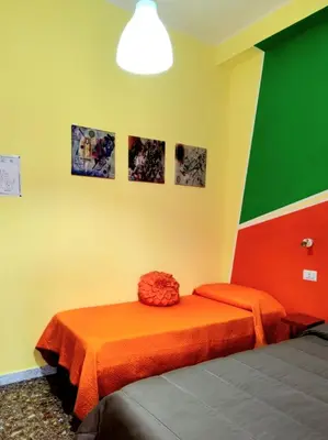a bedroom with a bed with an orange bedspread at Bed and Breakfast Mamma Giuliana in Rome