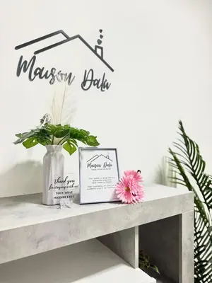 a sign for a mason table on a shelf with a flower at Maison DaLù in Rome