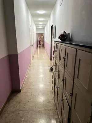 a hallway with a long corridor with pink and white walls at Sina Rent Room in Rome