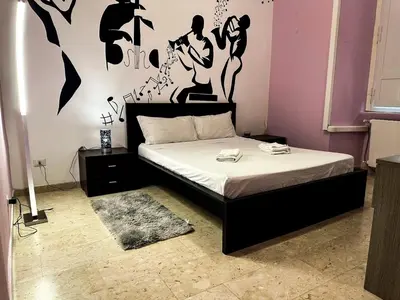 a bedroom with a bed with a black and white wall at Sina Rent Room in Rome